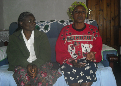 Dorothy (in red jersey) sitting with a friend at her home.